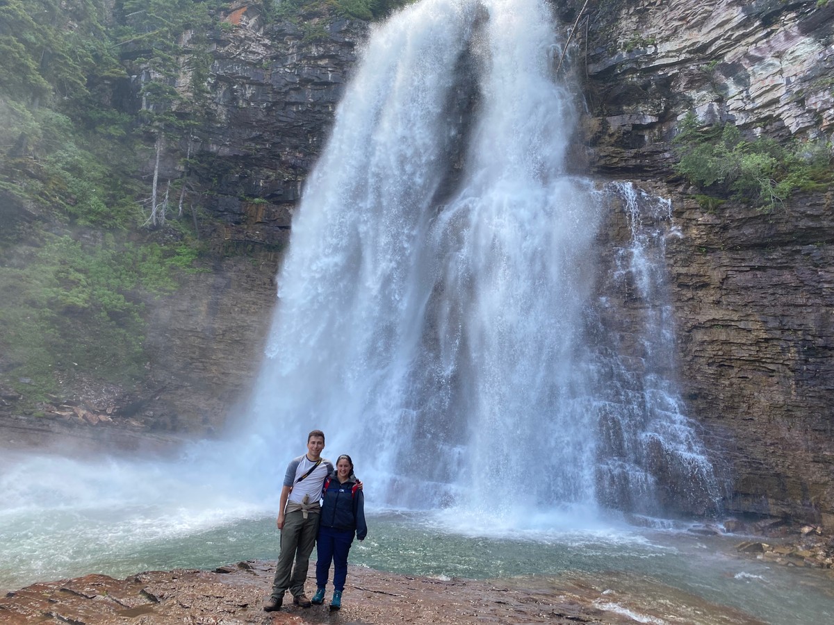a couple standing in front of a waterfall