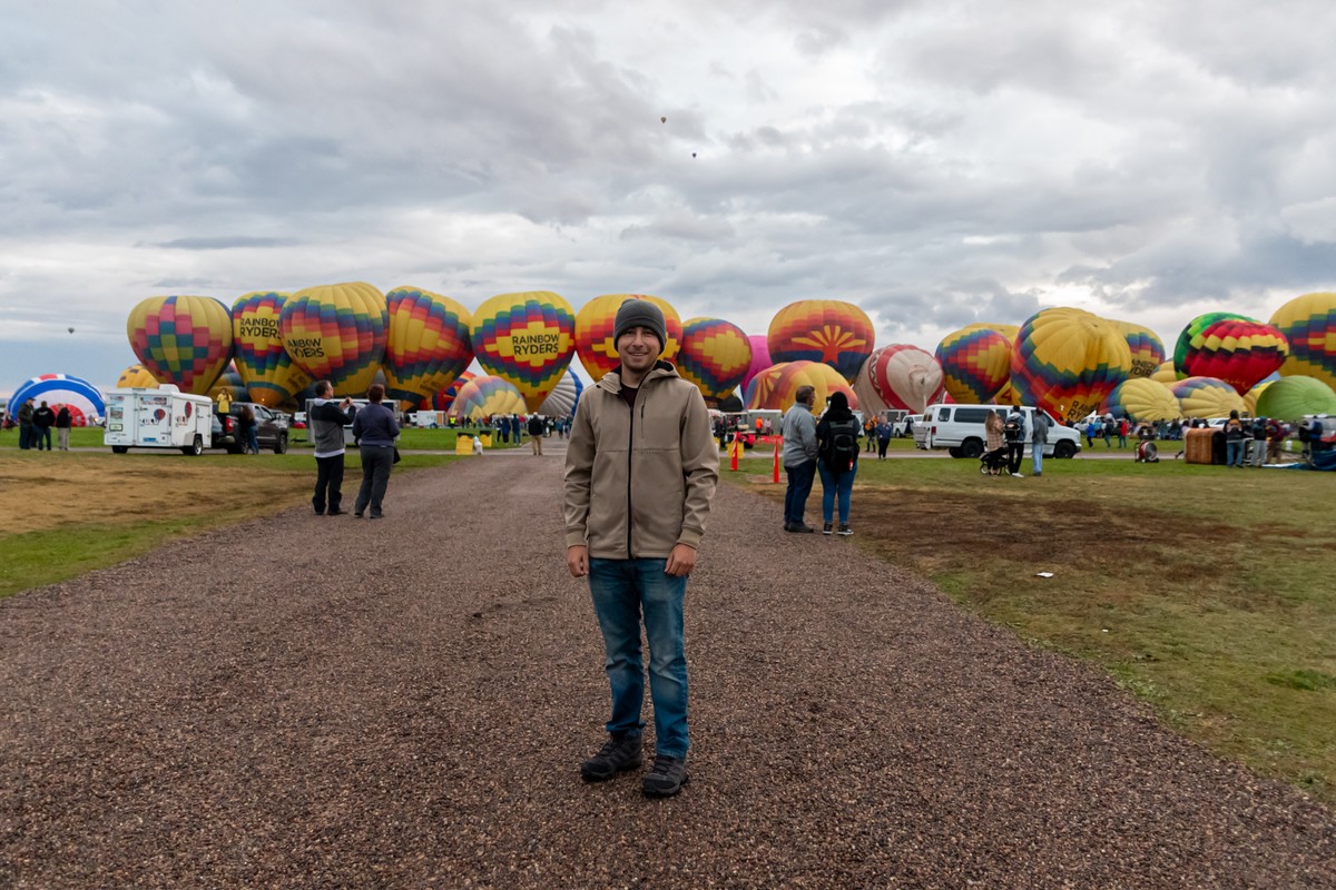 a person standing in front of a group of hot air balloons