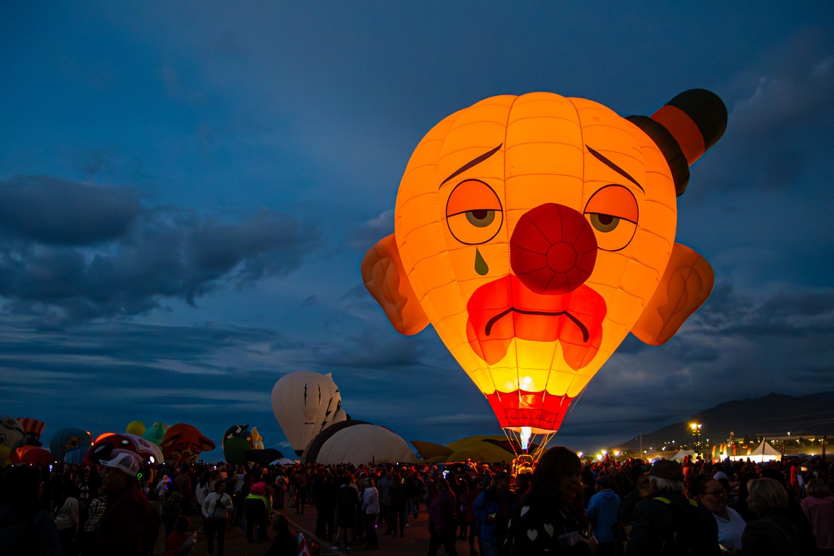 a large hot air balloon in the sky with a crowd of people