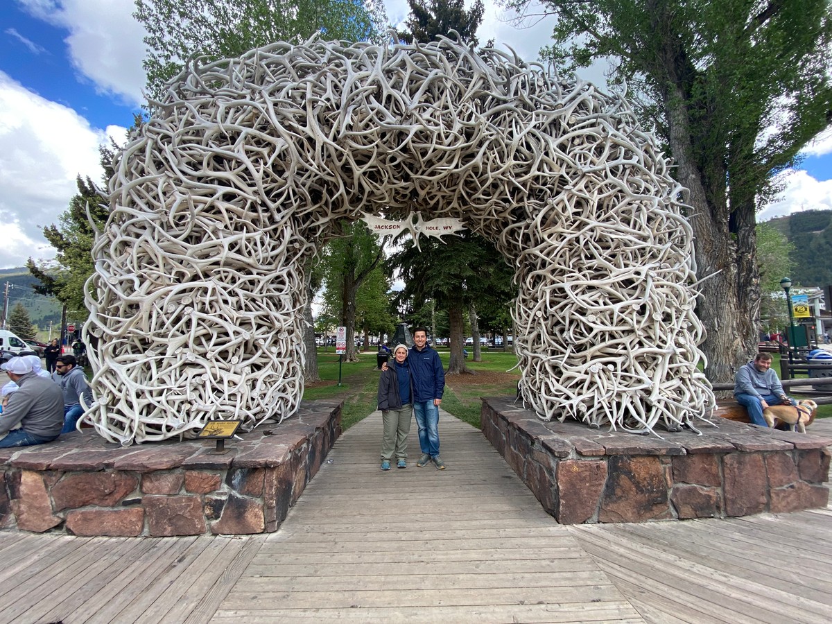 a man taking a picture of a structure made of sticks