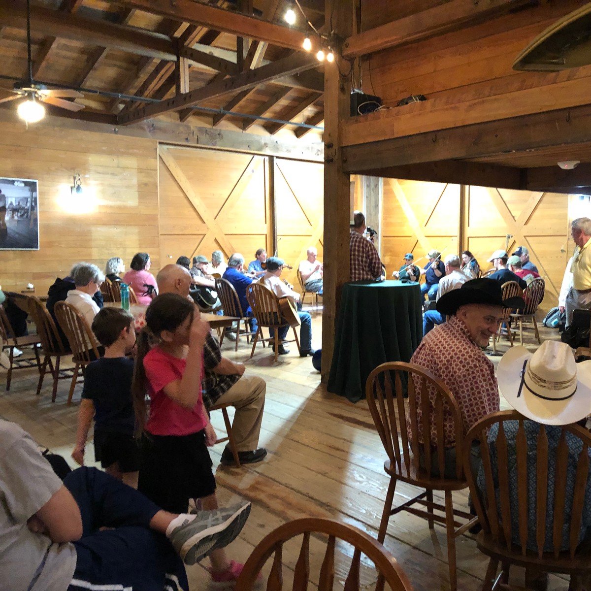 a group of people sitting in a room with tables and chairs