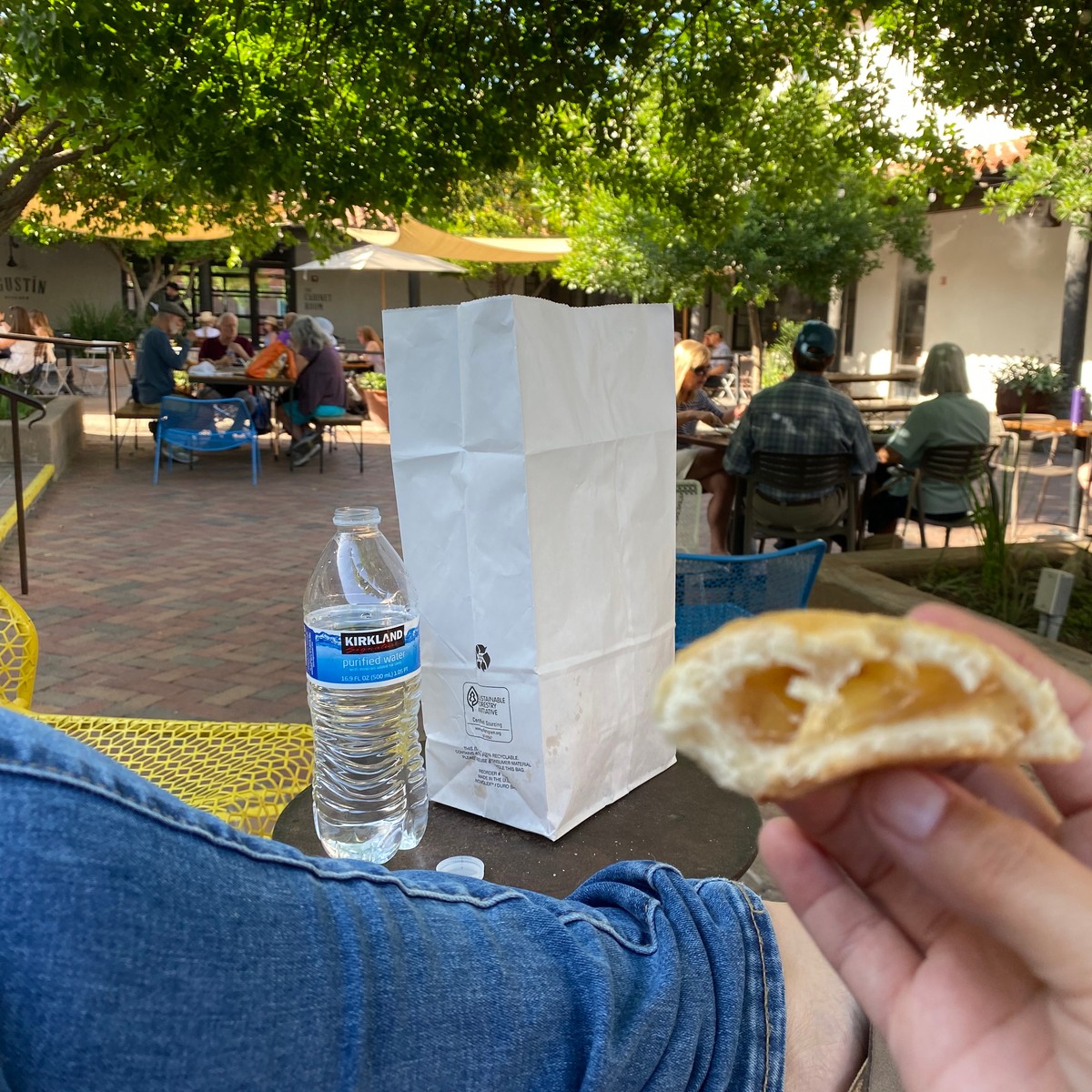 a person holding a donut and a water bottle