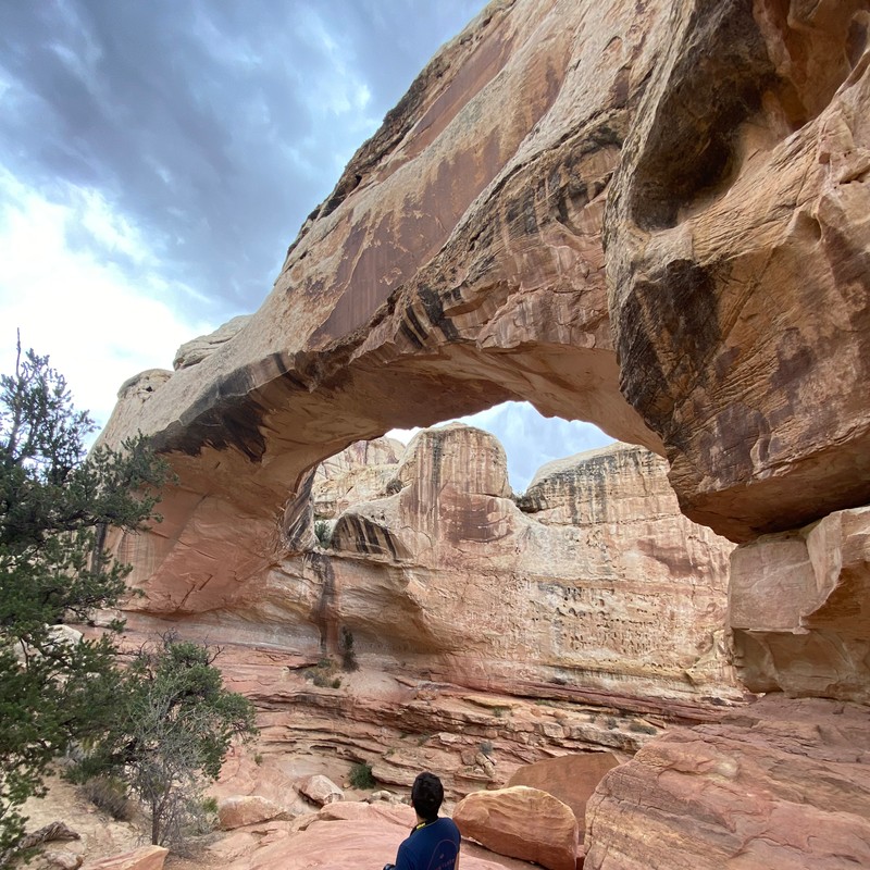 a person standing in front of a large rock formation