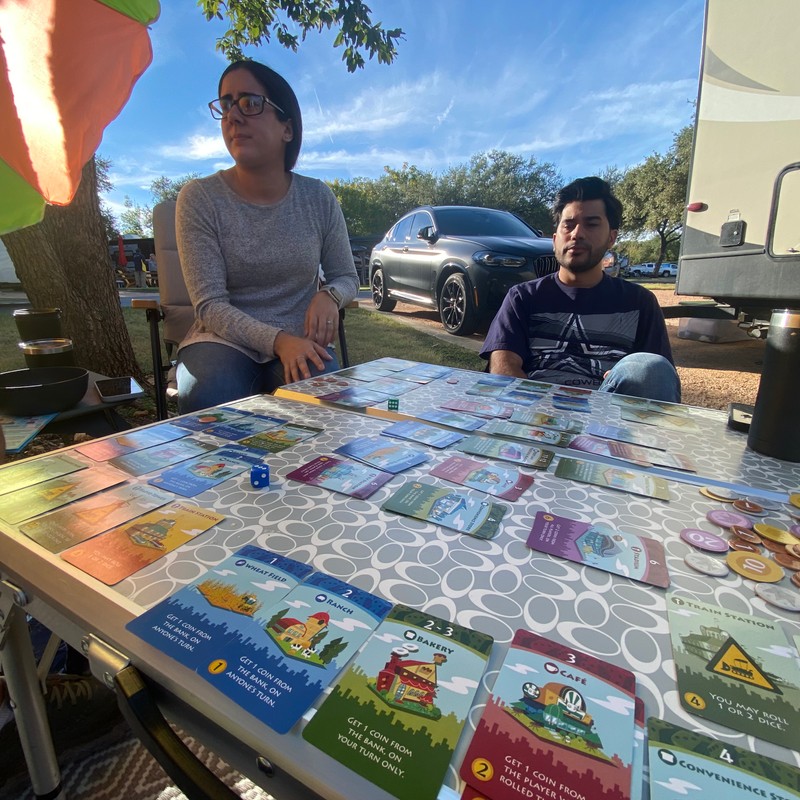 a couple of men sitting at a table with a board game