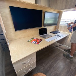 a desk with a laptop and a tv on it