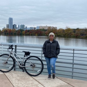 a person standing on a bridge over a body of water with a city in the background