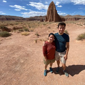 a man and a woman posing in front of a desert landscape