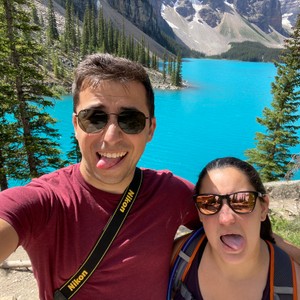 a man and woman taking a selfie by a lake