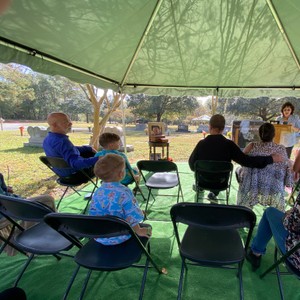 a group of people sitting at a table under a tent