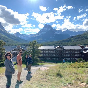 a group of people walking on a path in front of a building