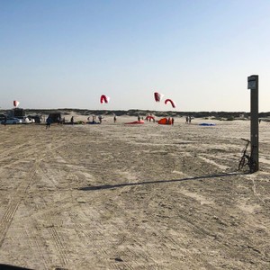 a group of people flying kites on a beach