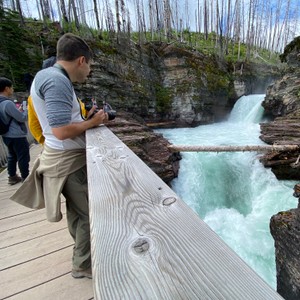 a person taking a picture of a waterfall