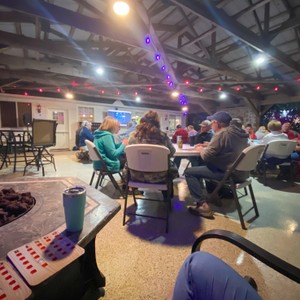 a group of people sitting in a room with tables and chairs