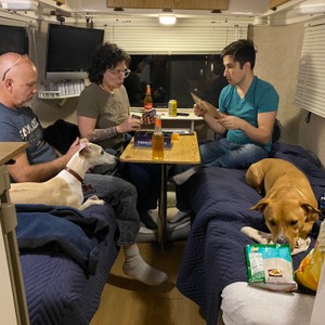 a group of people sitting in a living room with a dog