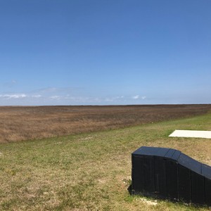 a field with a building in the distance