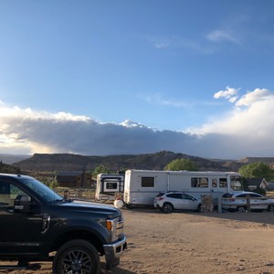 a group of vehicles parked in a field with a mountain in the background