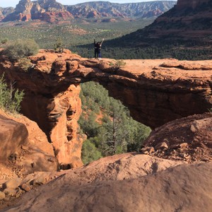 a person standing on a rock bridge