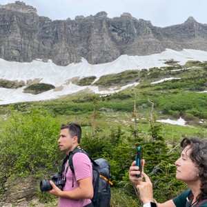 a man and woman taking a picture in front of a mountain