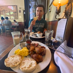 a person sitting at a table with food and drinks