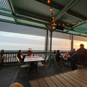 a group of people sitting at a table on a deck