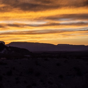 a landscape with hills and a sunset