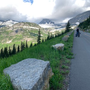 a person riding a bicycle on a road in a mountainous region