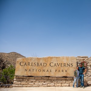 a couple of people standing in front of a sign