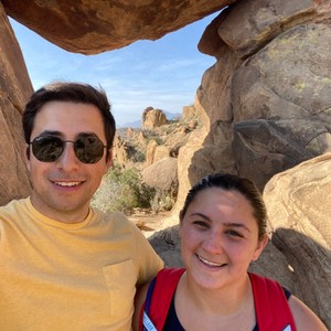 a man and woman taking a selfie in front of a rock formation