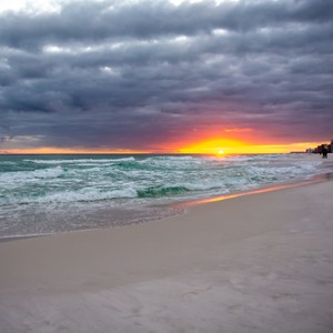 a beach with waves and a sunset