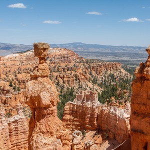 a rocky canyon with trees with Bryce Canyon National Park in the background