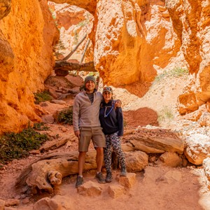 a man and woman posing for a picture in front of a rock formation