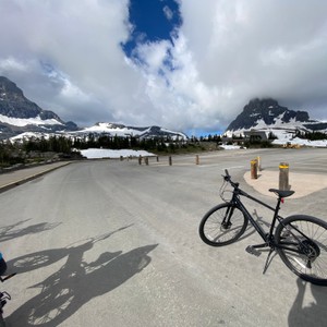a bicycle parked on a road with mountains in the background