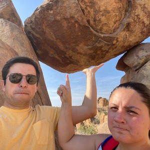 a man and woman posing for a picture in front of a rock formation