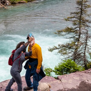 a man and woman kissing by a river