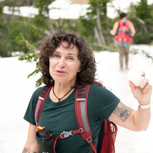 a person with a backpack and a backpack holding a white object