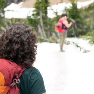 a woman looking at a man walking on a path