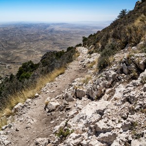 a rocky hillside with a grassy hill