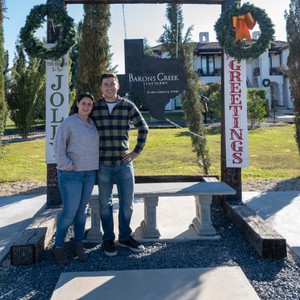 a man and woman standing in front of a sign