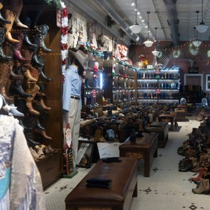 a store with a person standing in the middle of a room full of shoes and a table